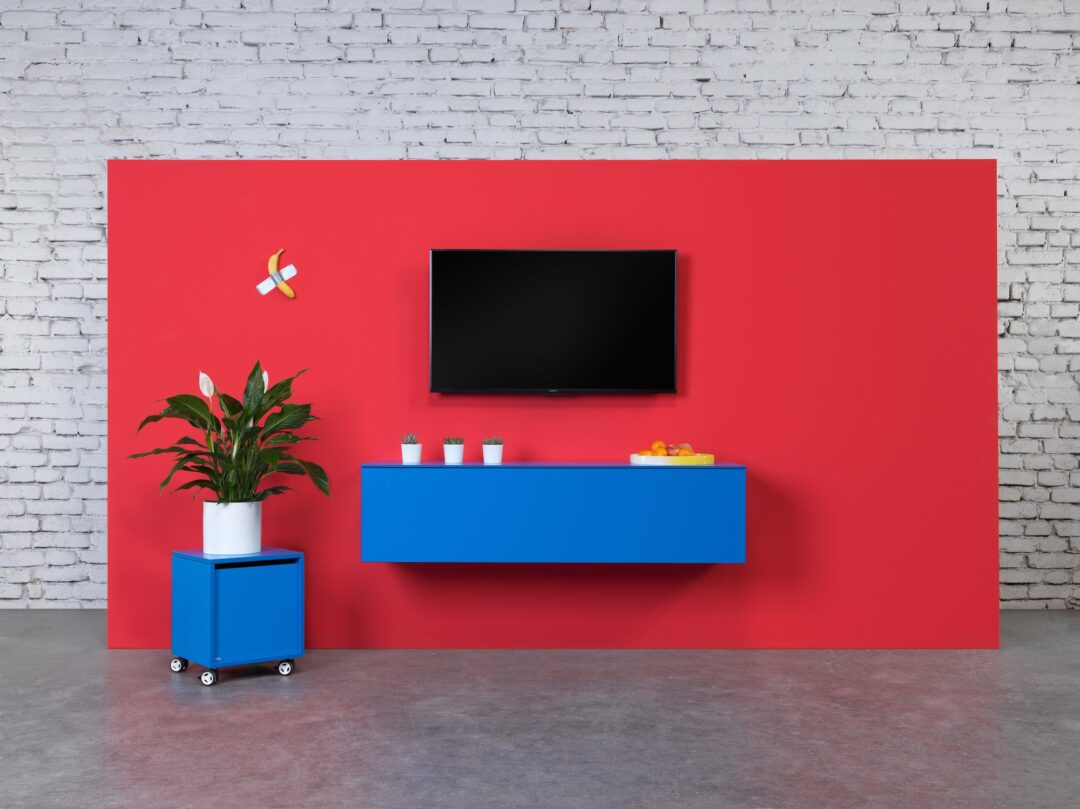 bildstadt – Hali Imagefotografie rote Fernsehwand mit blauem Lowboard und Rollkasten