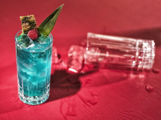 bildstadt Foodfotografie – Kenny Klein Cocktails – blauer Cocktail auf rotem Hintergrund und einem leeren Glas